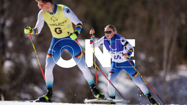 A female Athlete and their guide competing in Nordic skiing
